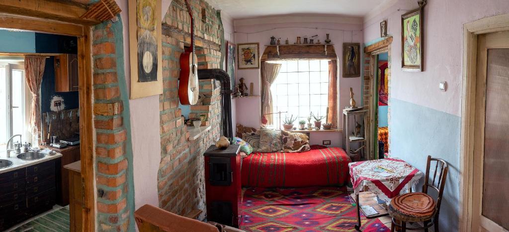 a room with a red couch and a brick wall at At Home Hostel in Korçë