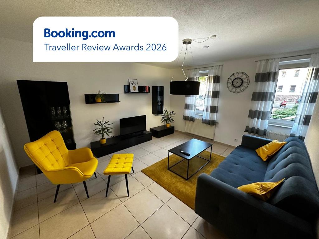 a living room with a blue couch and yellow chairs at Giulia Ferienwohnung - Zentral in Tuttlingen