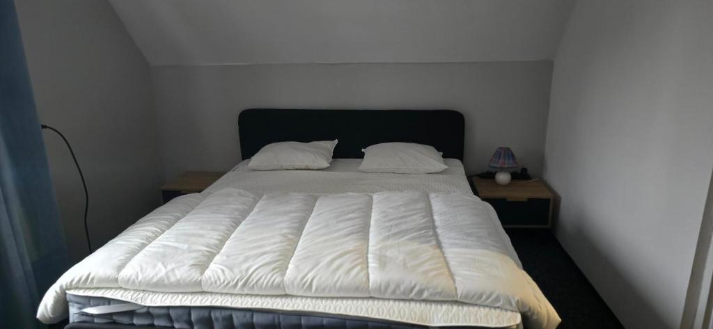 a bed with a white comforter in a bedroom at Rancho U Bodzia in Jeleniów