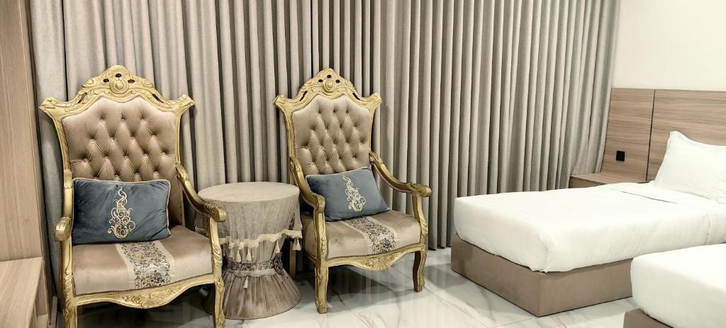 a hotel room with two chairs and a bed at قمة قباءللشقق المفروشه1 in Medina