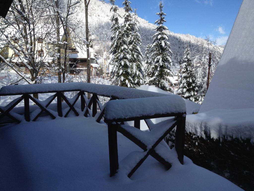 a bench covered in snow with a mountain in the background at Holiday Home Minja in Kopaonik