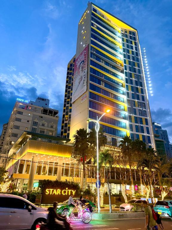a tall building with people riding bikes in front of it at Grands StarCity in Nha Trang