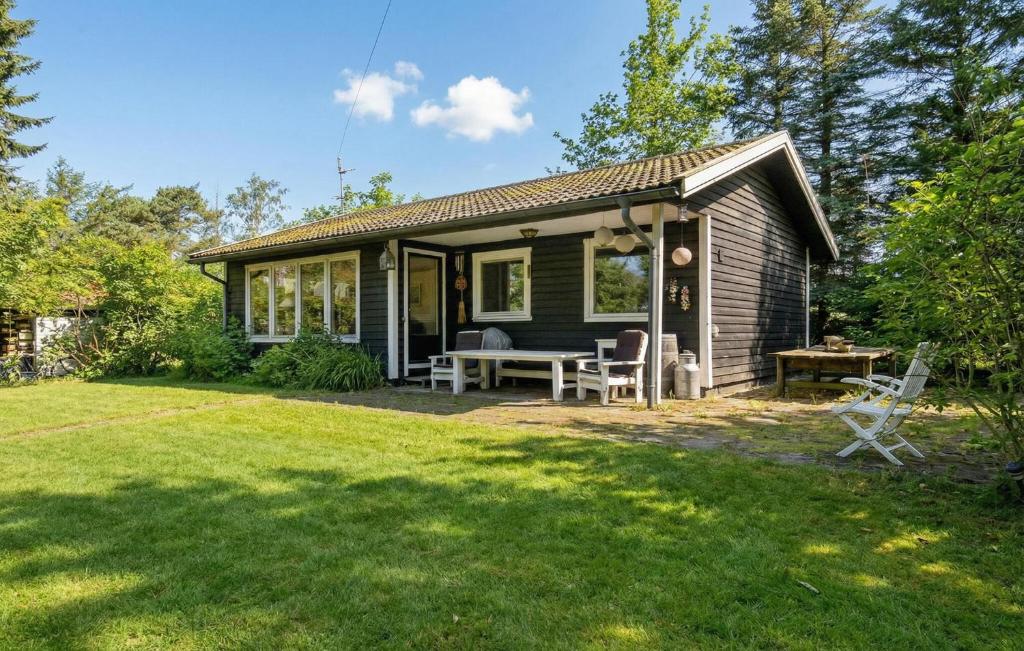 a small house with a table and chairs in a yard at 2 Bedroom Beautiful Home In Orø in Orø