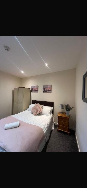 a bedroom with a large bed and a night stand at 36 flat 1 - Room 2 in Swansea