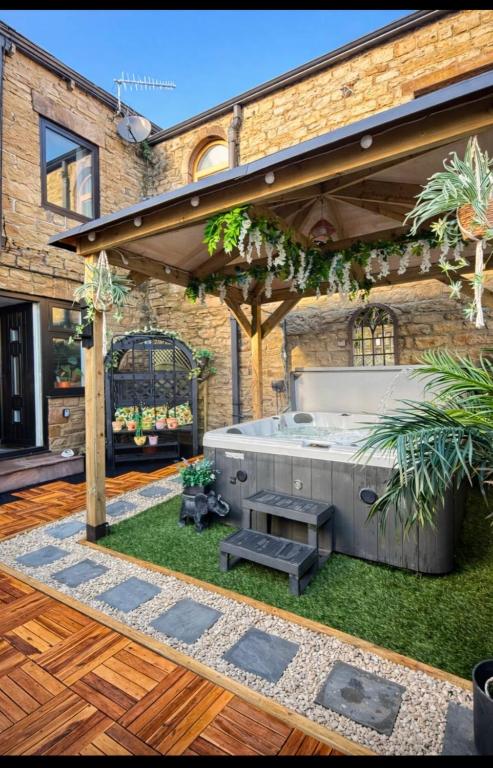 a patio with a hot tub in a yard at Yorkshire Barn Escape 2 bedroom in Keighley