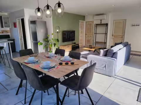 a living room with a wooden table and chairs at Newlook 1 in Trélissac