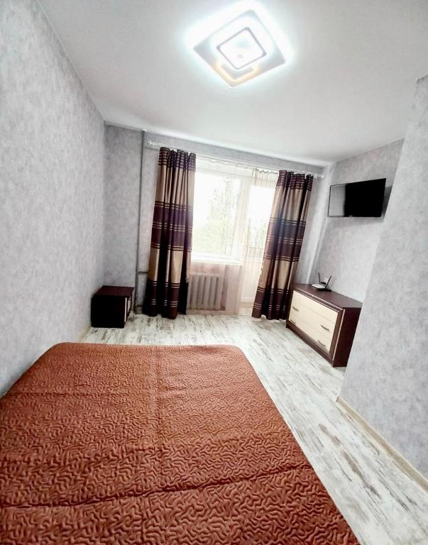 a bedroom with a large orange bed and a window at Уют in Kropyvnytskyi