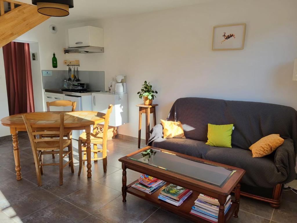 a living room with a couch and a table at Gîte Volcans - 1-4 pers, au calme à 20 mins de Vulcania, Puy-de-Dôme et Lemptegy, 35 mins du Mont Dore et du Sancy in Gelles