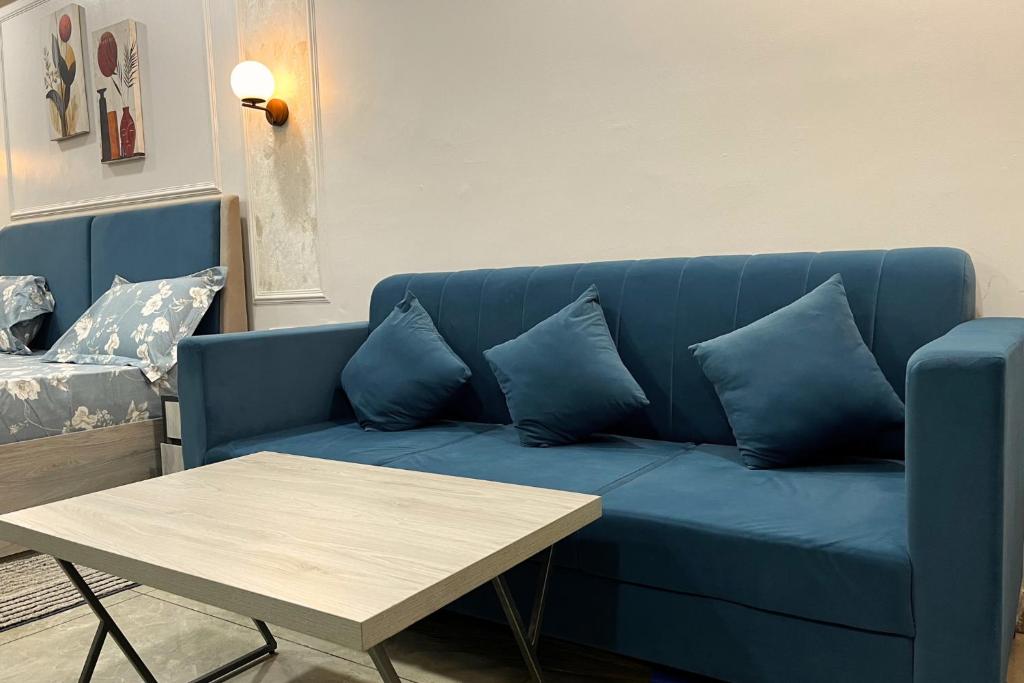 a blue couch with blue pillows and a table at Nova Nest in Jaipur
