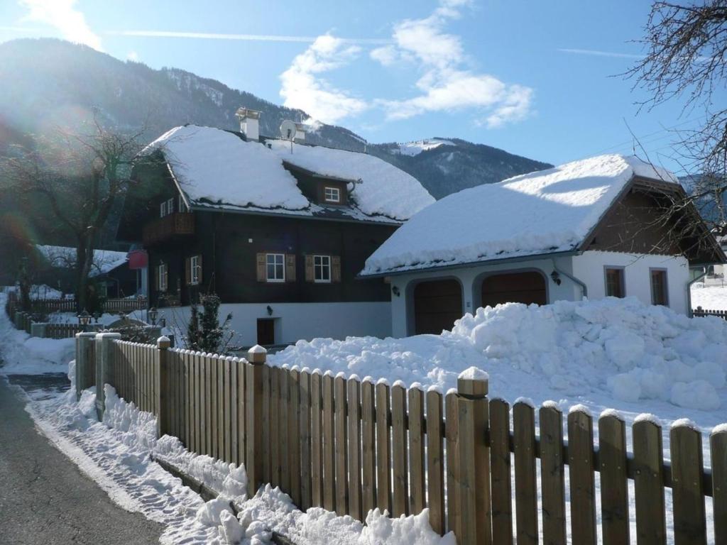 a house covered in snow next to a fence at Ferienhaus Almenblick in Fellbach