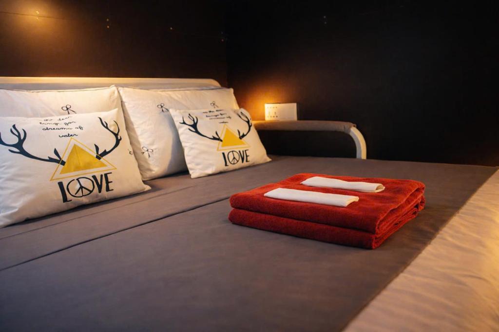 a bed with a red ottoman sitting on top of it at Start House 5 mins walk Airport in Ho Chi Minh City