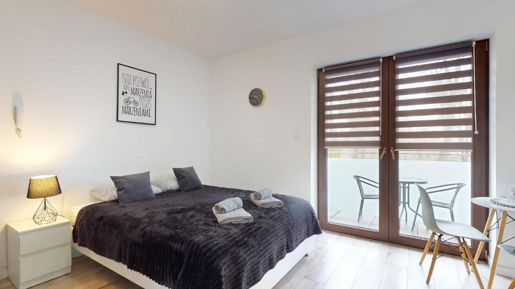 a bedroom with a bed and a table with chairs at Studio Fibra Lungo in Rybnik