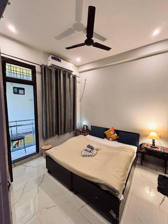 a bedroom with a bed and a ceiling fan at OLT Hostel Rishikesh in Rishīkesh