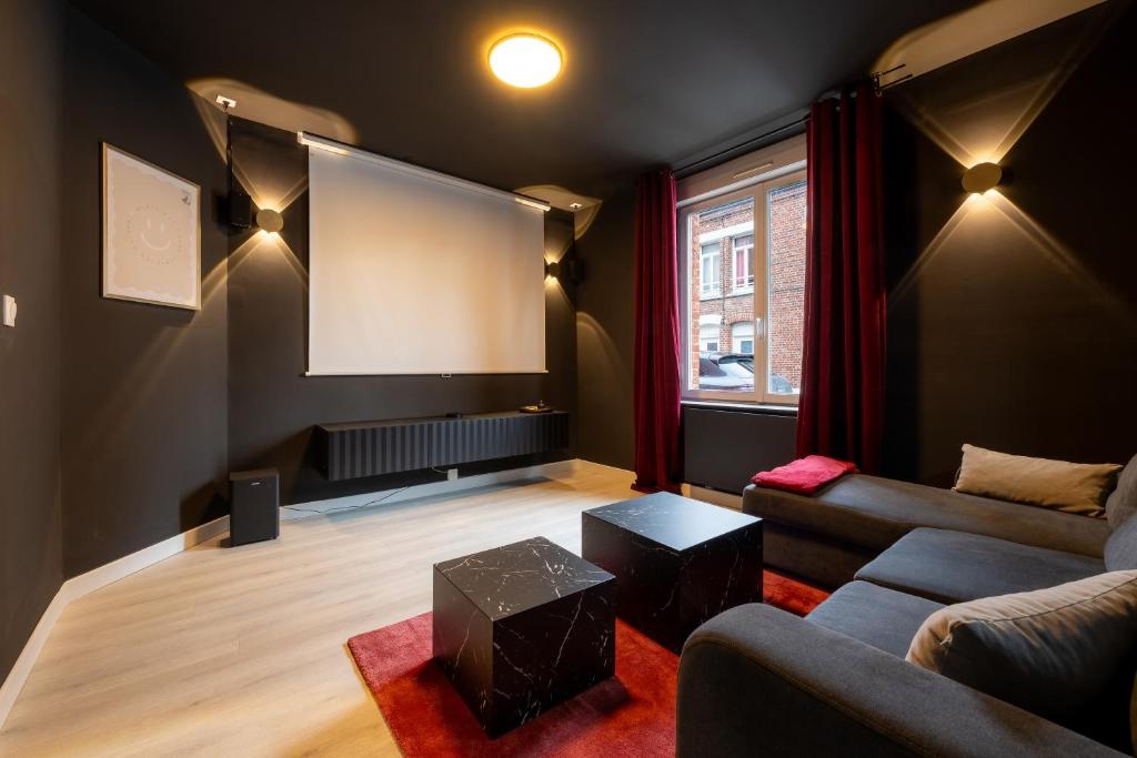 a living room with a couch and a flat screen tv at Ciné Suite - Arras 5 guests in Arras