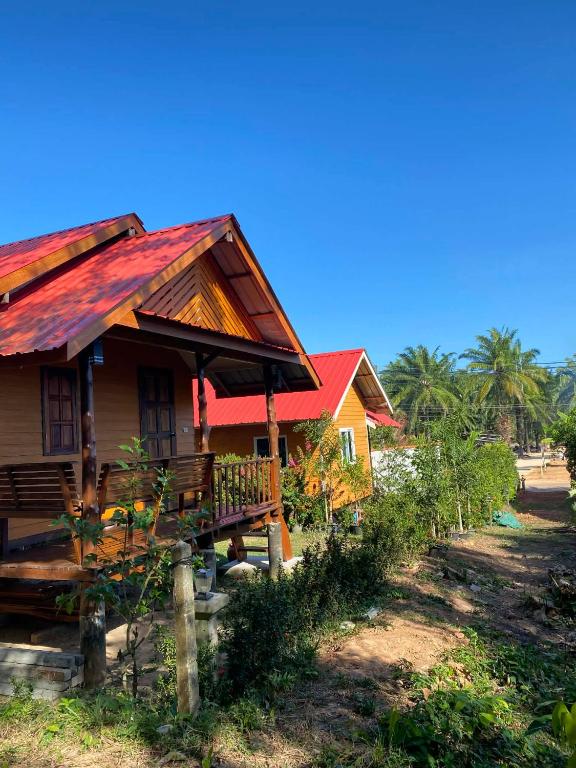 a small house with a red roof on a beach at Panan Homestay Kohpu in Ban Na