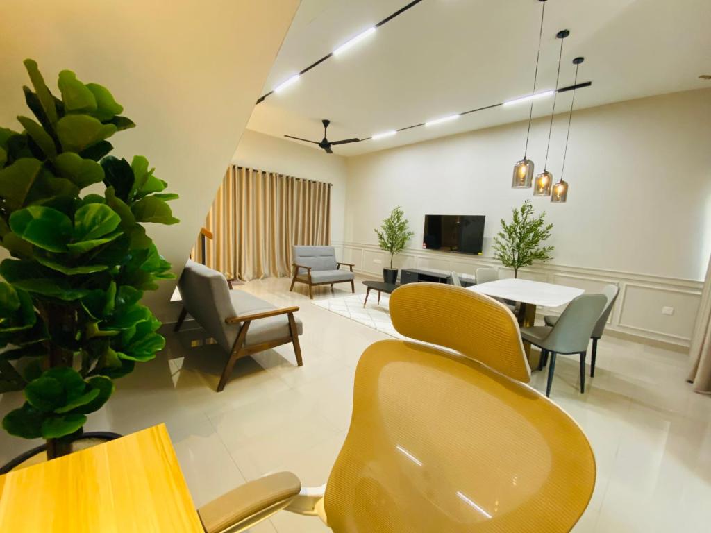 a living room with chairs and a table and a tv at Hanah Home Pagoh in Pagoh