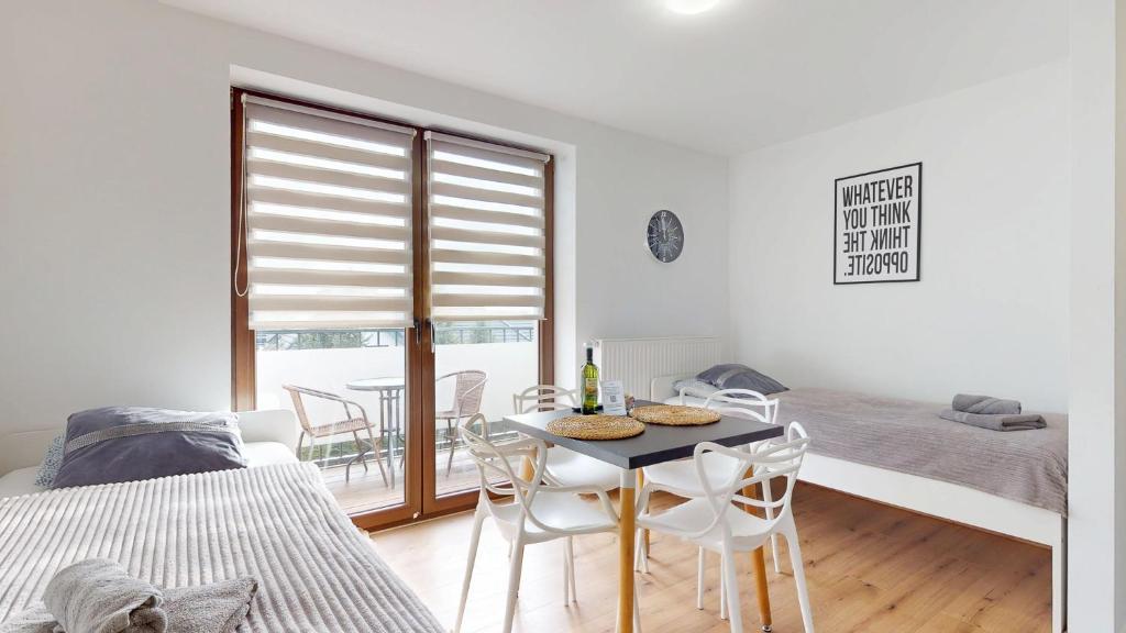 a room with a table and chairs and a bed at Apartament Fibra Cortado in Rybnik