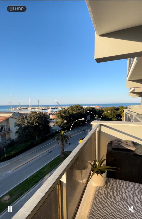 a suitcase on a balcony with a view of a street at Blue Zen beachfront apartment in Civitanova Marche