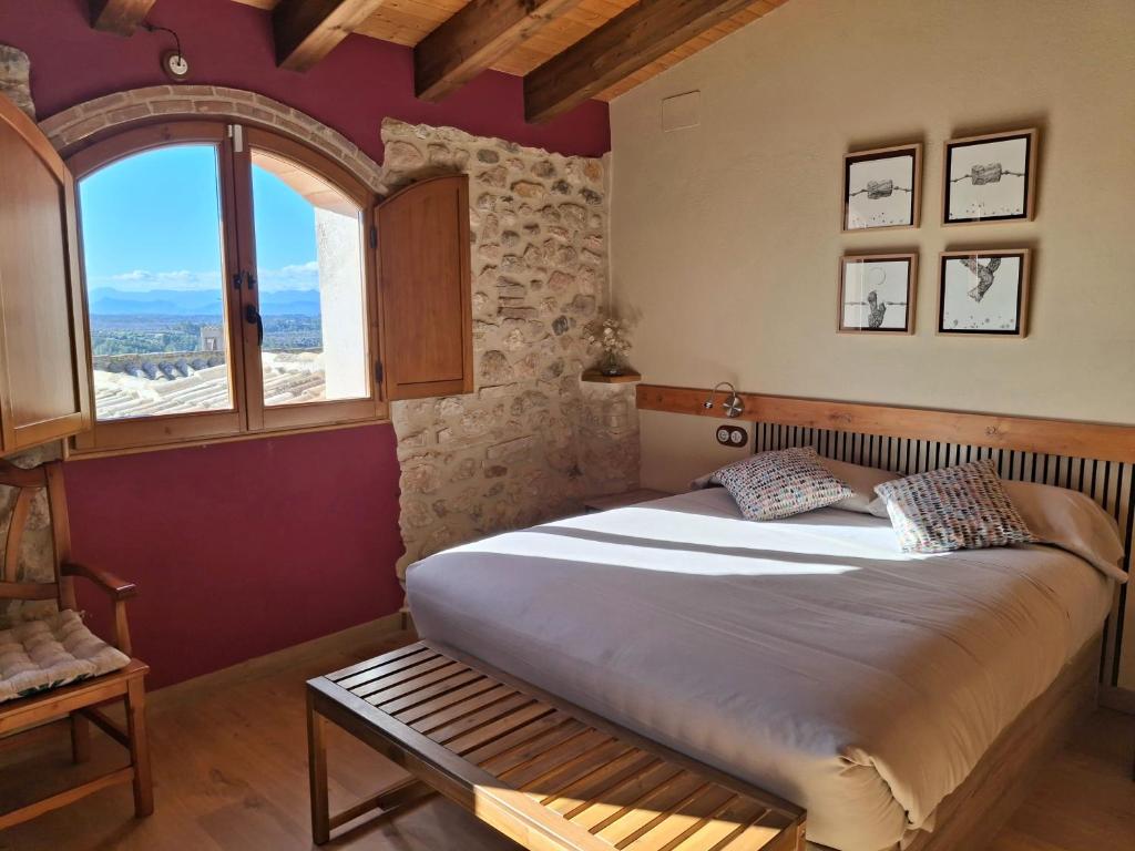 a bedroom with a large bed and a window at Ca la Pubilla in Masroig