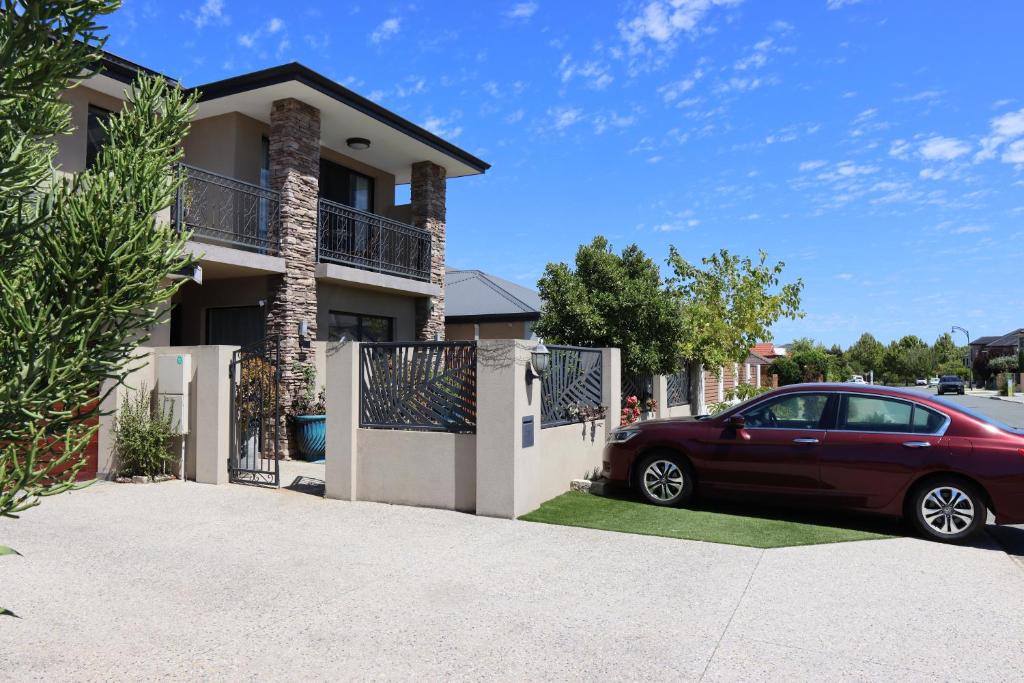 a red car parked in front of a house at Midby's Elegant Guesthouse - 2 En-suite Rooms & 2 Rooms with Shared Bathroom in Perth