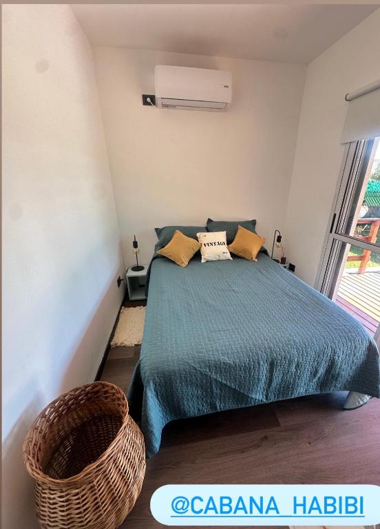 a bedroom with a bed with a green comforter at Cabaña Habibi in Potrero de Garay
