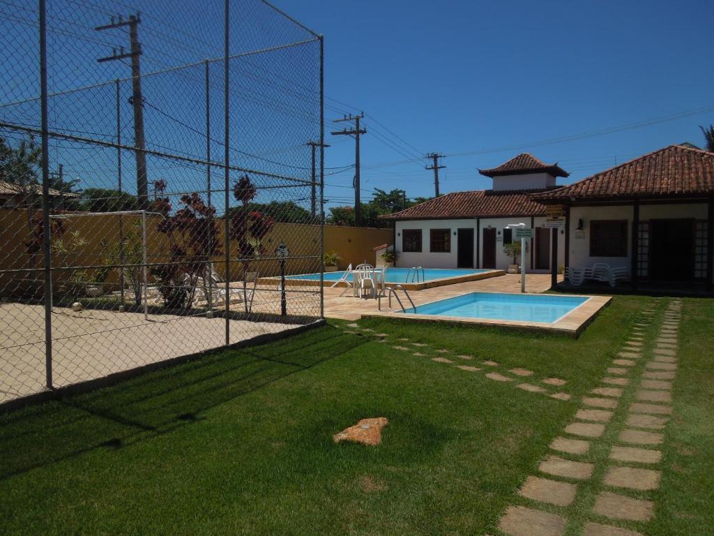 una valla frente a un patio con piscina en Casa aconchego Geribá canto direito 2Q com WiFi, en Búzios