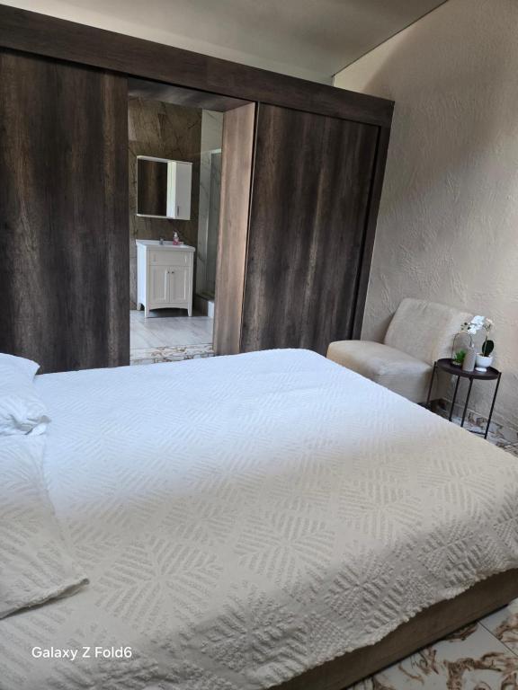 a bedroom with a large white bed and a chair at Swakhanya Haus in Vereeniging
