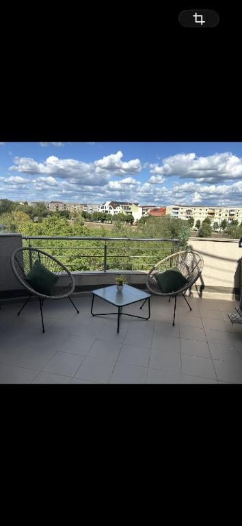 a balcony with two chairs and a table with a view at Rotonda apartment in Lugoj