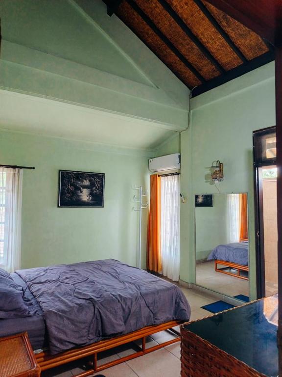a bedroom with a bed and a mirror at Widi House in Nusa Dua