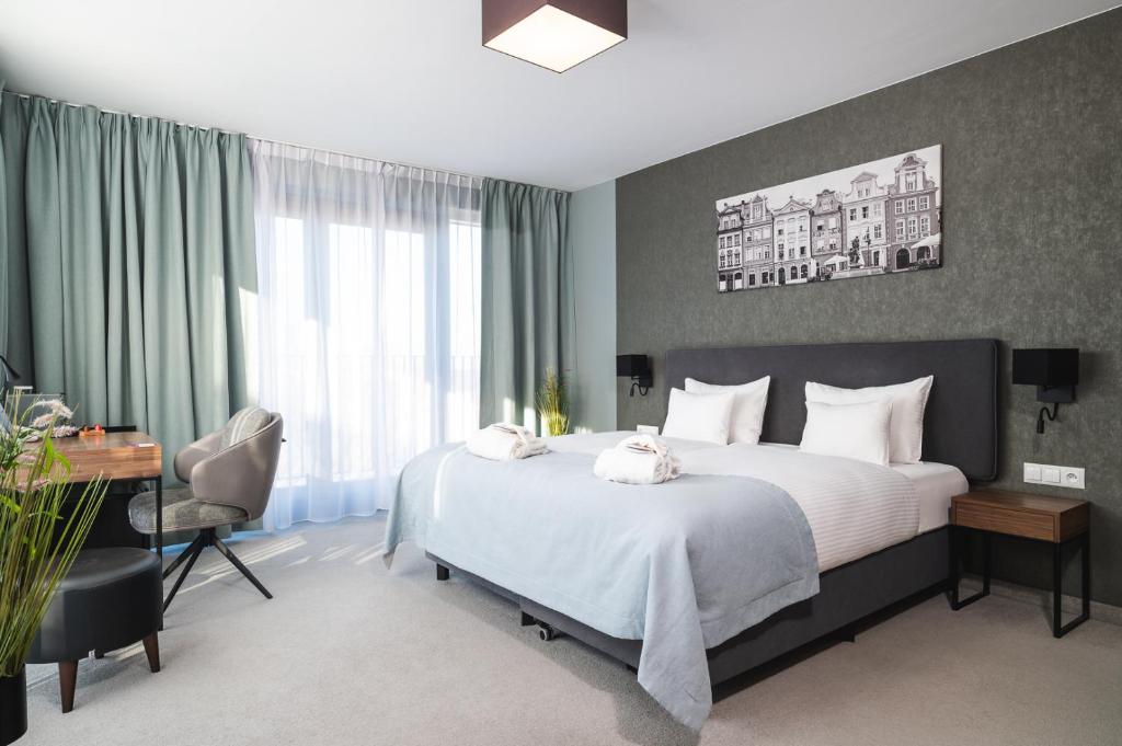 a bedroom with a large bed with a desk and a desk at Focus Hotel Poznań in Poznań