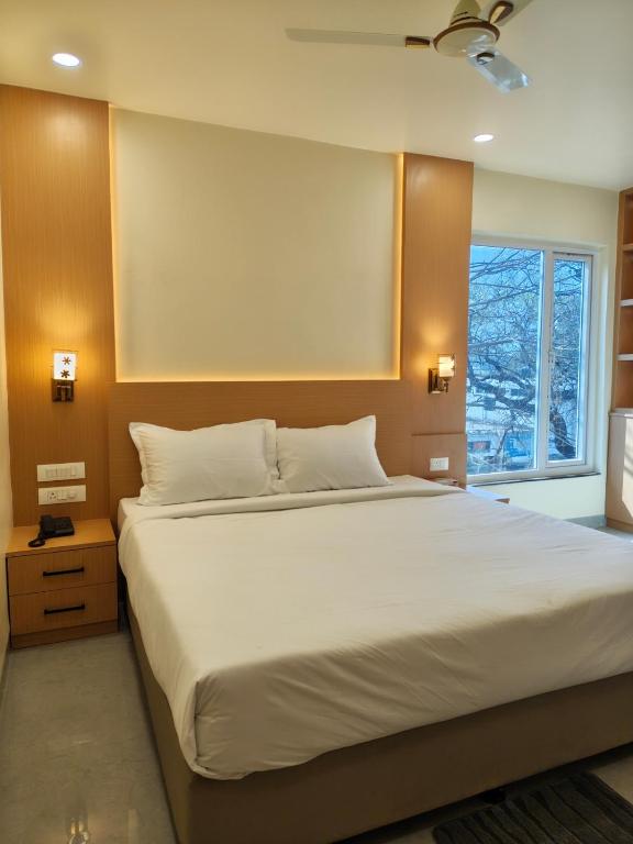 a bedroom with a large white bed with a window at Hotel Heritage Inn in Samastīpur