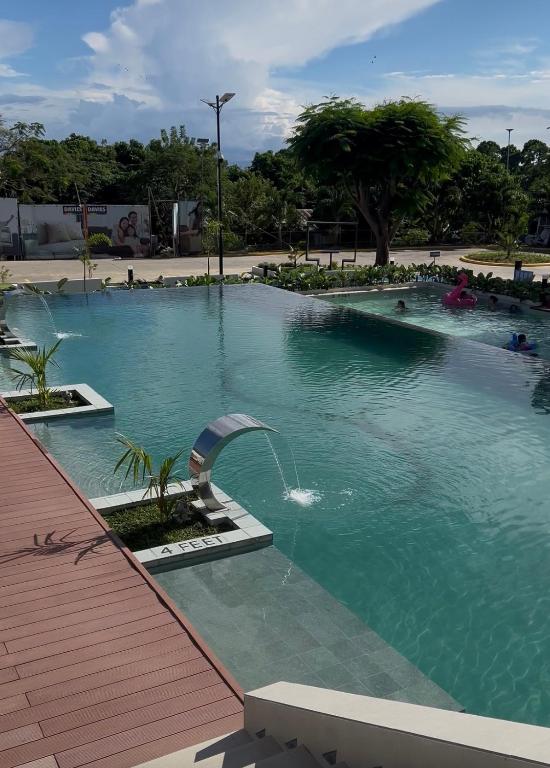 a large pool of water with people in it at Antara Condomium 2 studio unit in Talisay