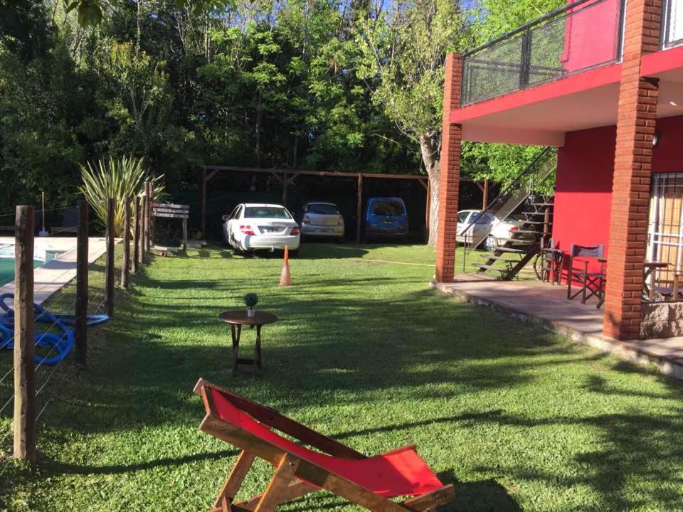 a yard with a red bench next to a building at Ayma in Chascomús