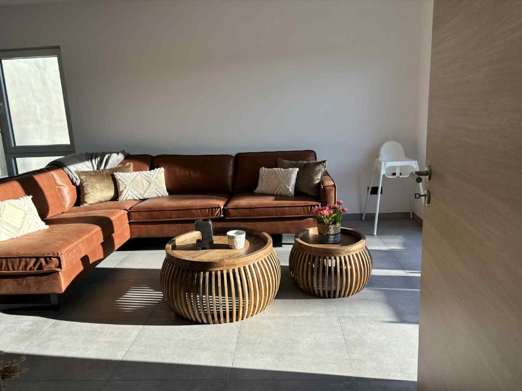 a living room with a couch and two large tables at L'ancien rucher in Hotton