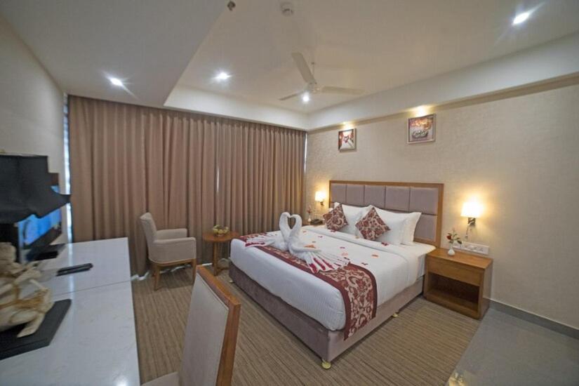 a hotel room with a large bed and a desk at Hotel Hill Palace in Jāmb