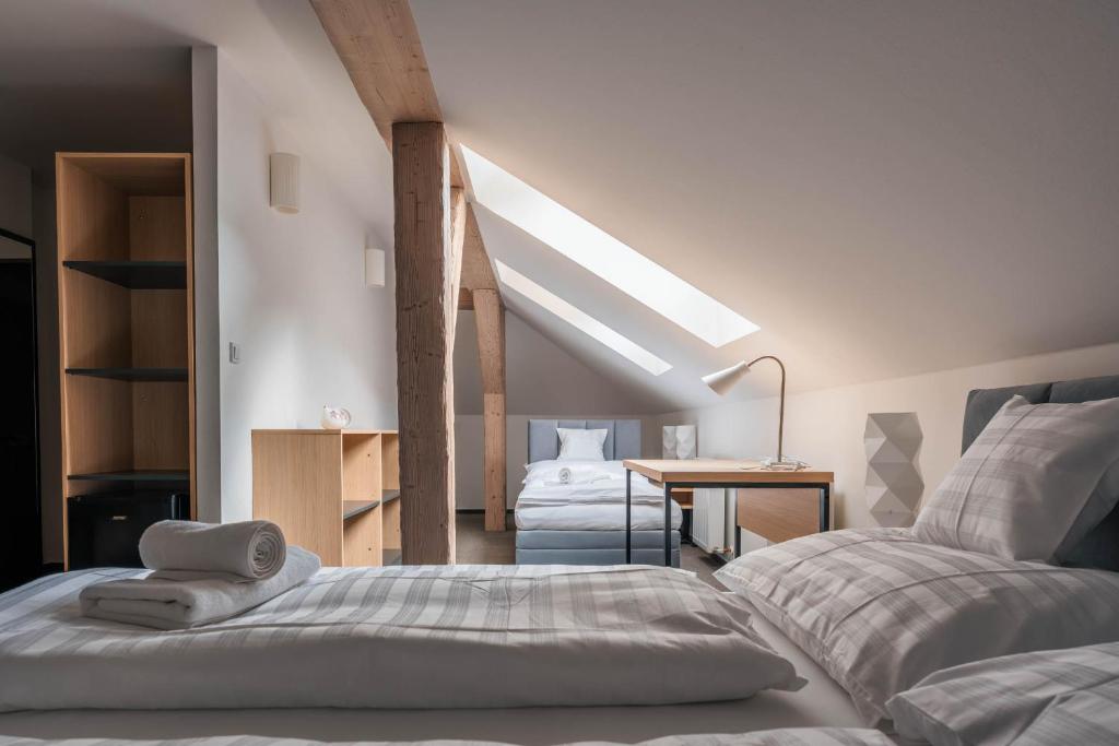 a attic bedroom with two beds and a desk at Formanka Hanušovice in Hanušovice