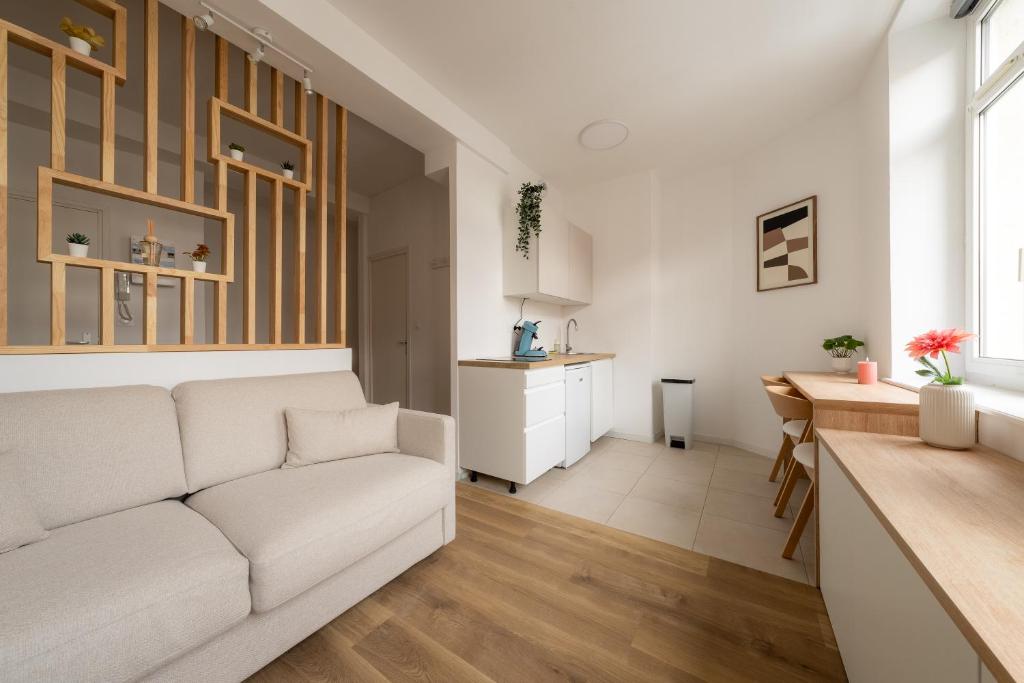 a living room with a white couch and a table at Le Cocoon Studio 2 voyageurs in Arras