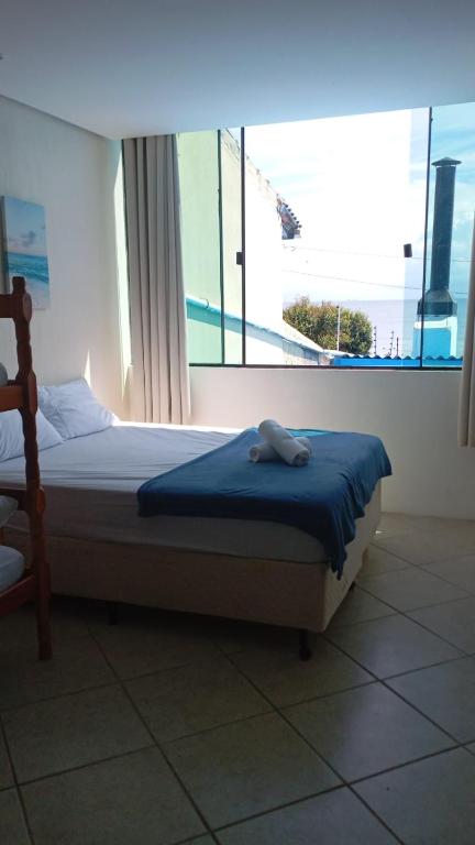 a bed in a room with a large window at Vista Beach Ingleses in Florianópolis