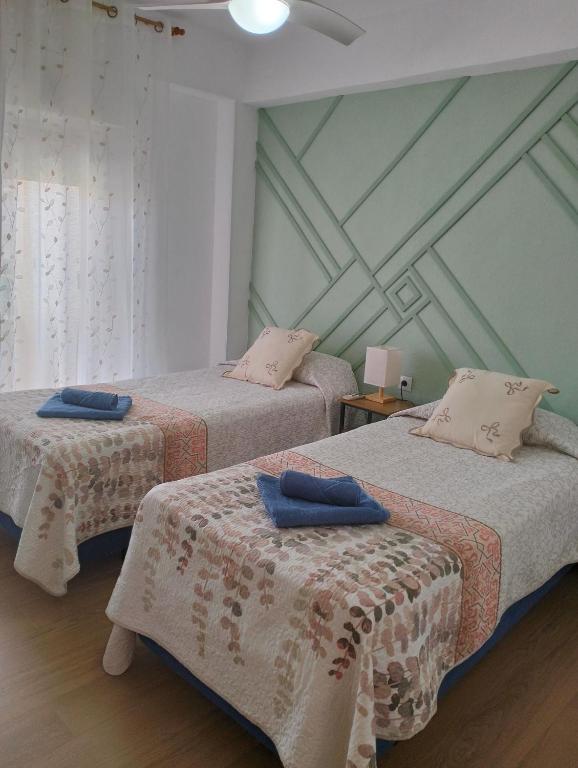 two beds in a room with a ceiling at Ricardo Hostal Apartamento in Alicante