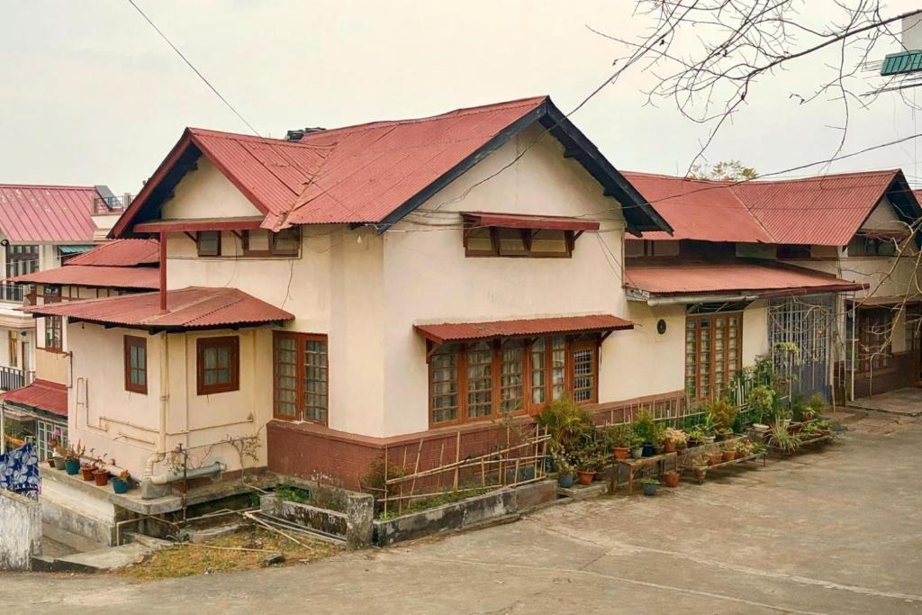 a house with a red roof on a street at Shillong Backpackers Hostel in Shillong