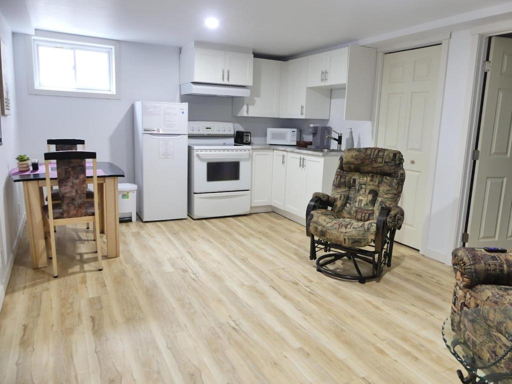 a kitchen with white appliances and a table and chairs at Small comfortable apartment in Saint-Nazaire