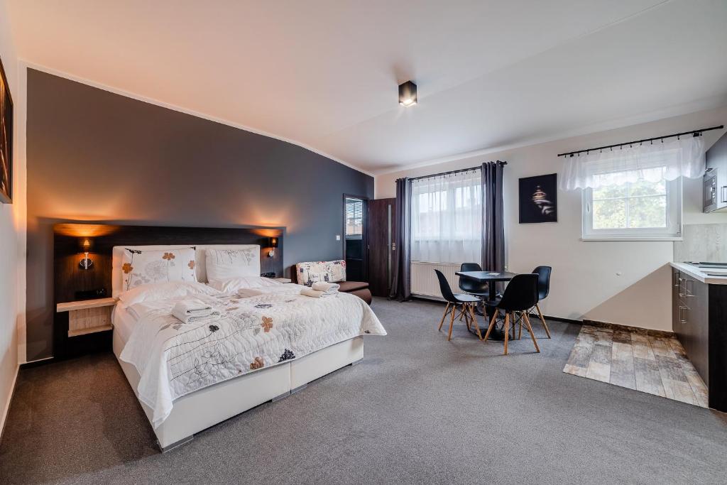 a bedroom with a large white bed and a table at Třeboňské Apartmány in Třeboň