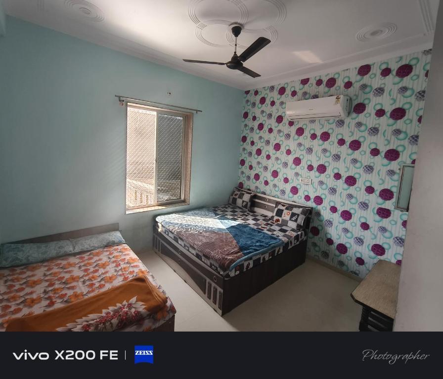 a bedroom with two beds and a ceiling fan at Hotel karishna palace in Rīngas