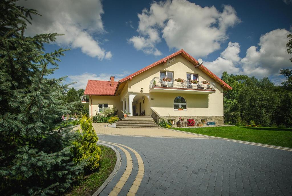 Biały dom z czerwonym dachem i podjazdem w obiekcie U Eskulapa w mieście Lutowiska