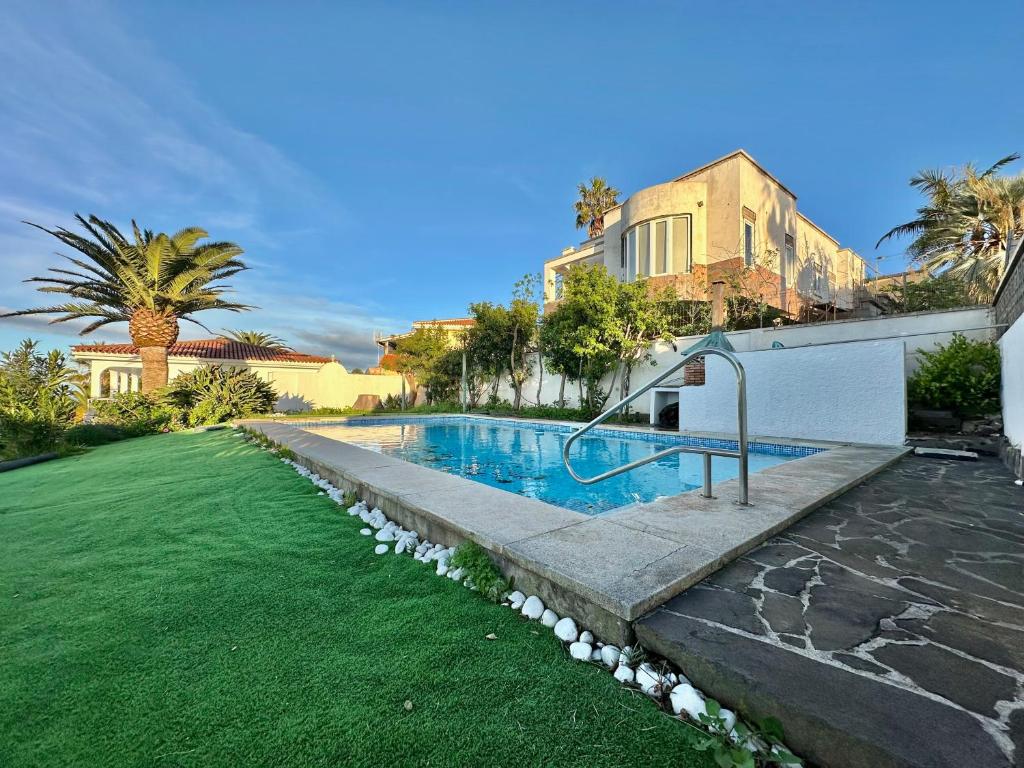 a backyard with a swimming pool and a grass yard at Esperanza in Tacoronte