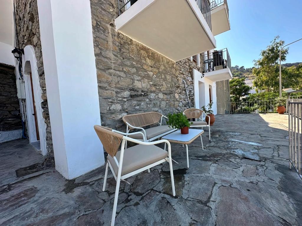 a patio with chairs and a table on a building at Evdilos blue serenity by BRP-PROPERTIES in Evdilos