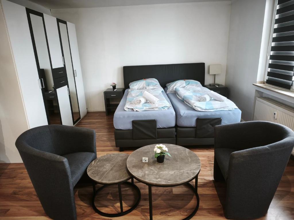 a bedroom with a bed and two chairs and a table at Apartment Sofia in Düsseldorf
