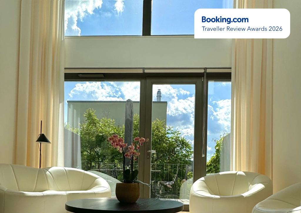 a living room with two chairs and a table and a large window at Townhouse Alaunpark in Dresden