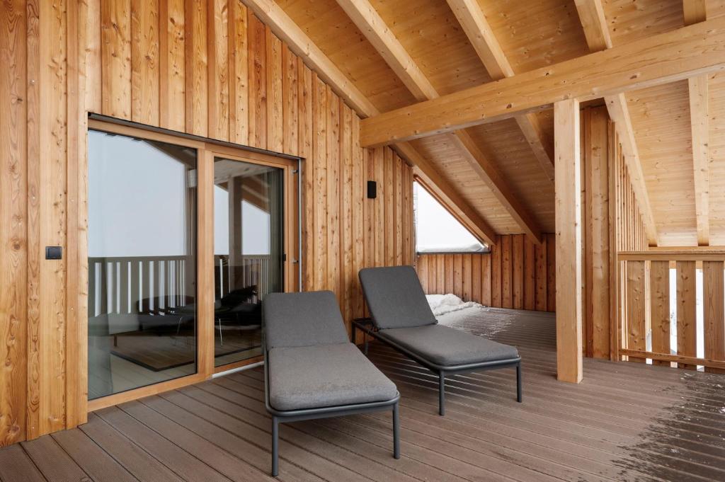 a room with two chairs on a wooden deck at Appartement Mia in San Genesio Atesino