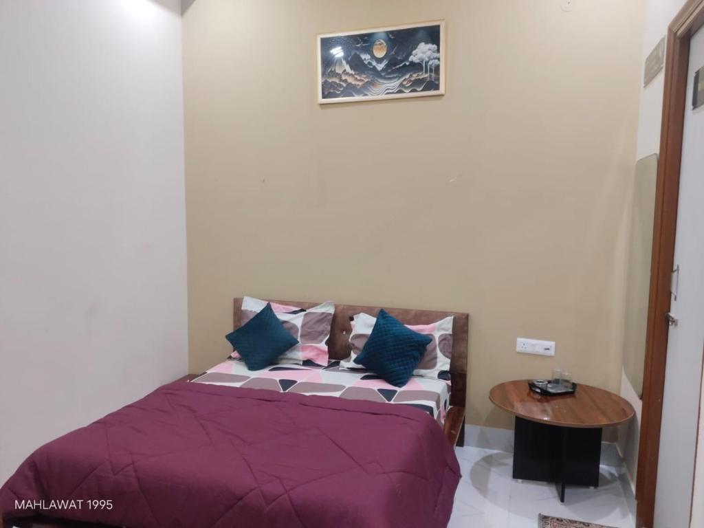 a bedroom with a bed with purple sheets and a table at Hotel Heaven Blu in Hodal